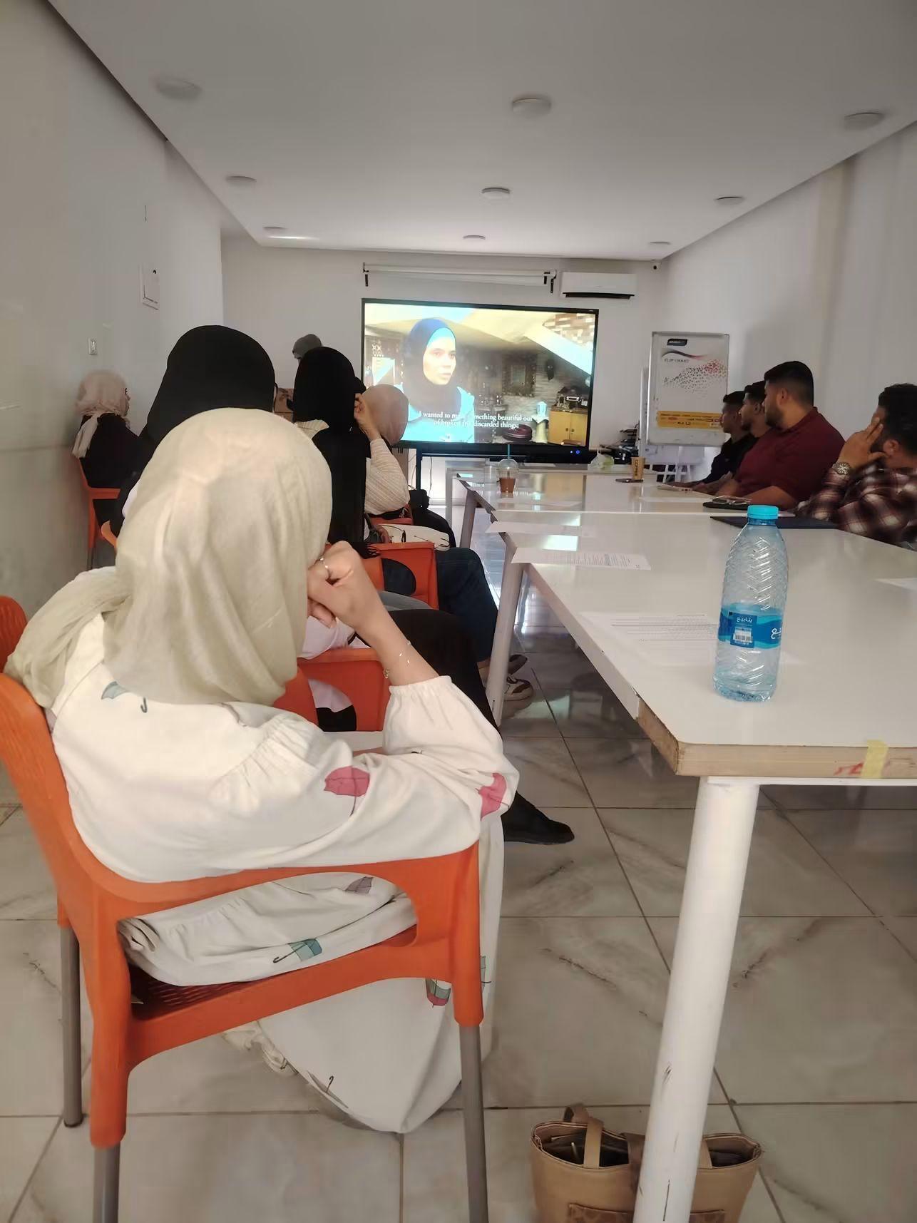 An audience watching a subtitled participatory-video screening