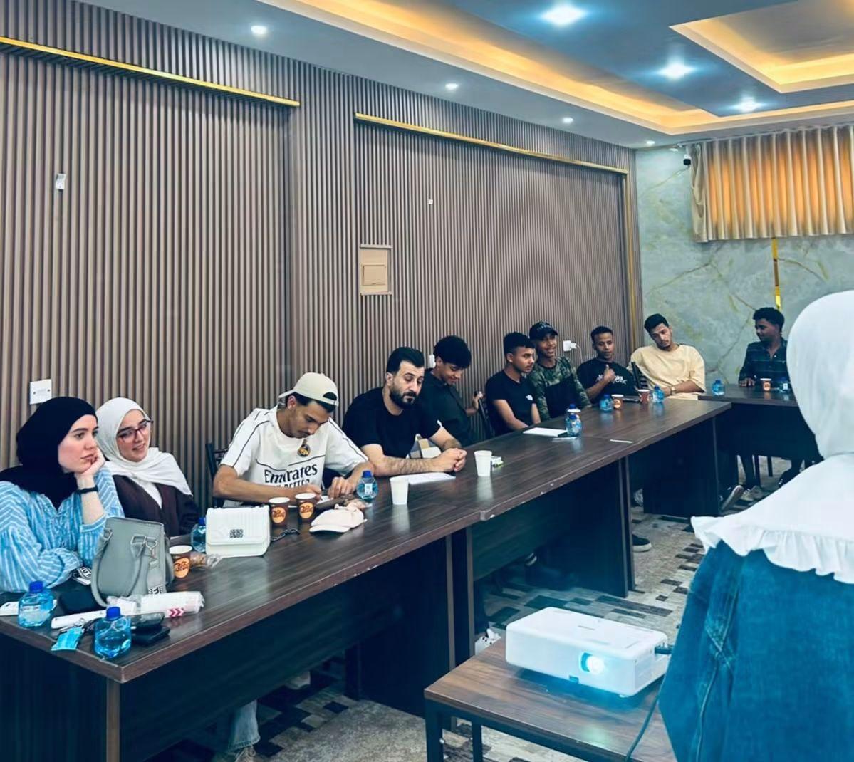 Young people around a conference table during a screening discussion