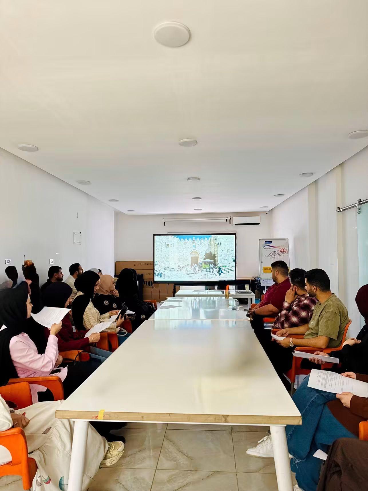 Participants watching a film at the far end of a meeting room